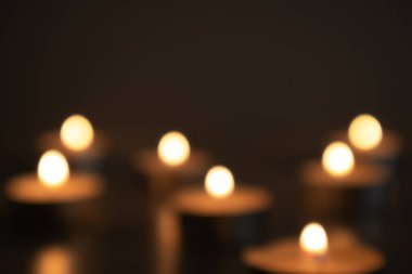Karanlıkta yanan mumların bulanık ışığı, yedi mum, bokeh