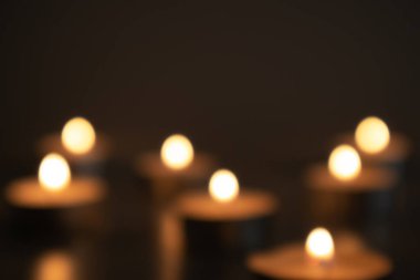 Blurred light of burning candles in the dark, seven candles, bokeh clipart