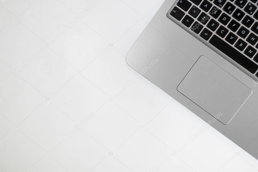 Flatlay: laptop in a plain white background, admistrative and e-commerce work