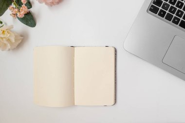 Kopya alanı ve dizüstü bilgisayarı olan boş bir defter. Düz yatıyordu. Üst aşağı perspektif