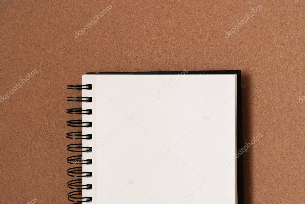 Blank sketchbook in cork background. Flat lay, copy space, top view