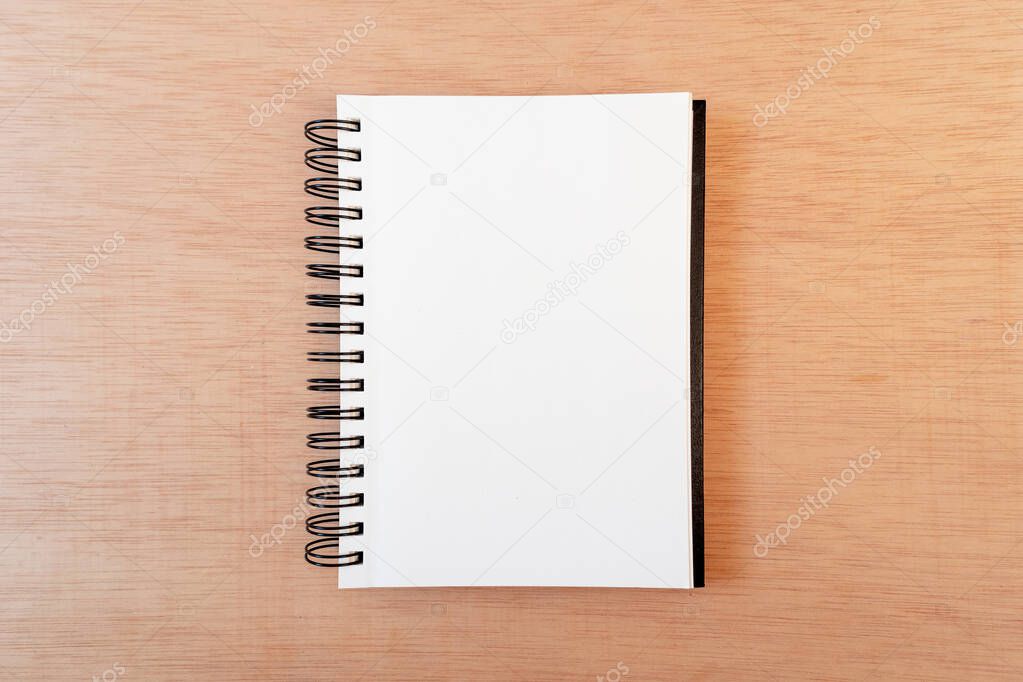 Blank notebook, ring binder, in wooden background. Flat lay, copy space, top down perspective