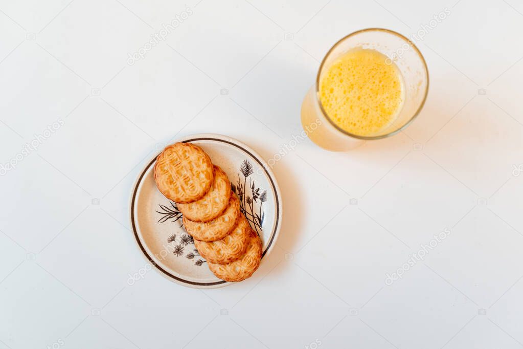 Top view of a breakfast: orange juice and cookie plate. Flat lay, copy space