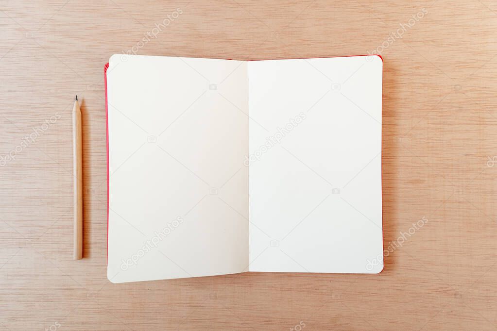 Blank open notebook with a pencil in a wooden background, flat lay, copy space, template
