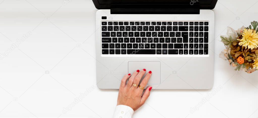 Banner with girl's hand on a laptop. Flat lay composition, with copy space for bloggers, magazines. Top view