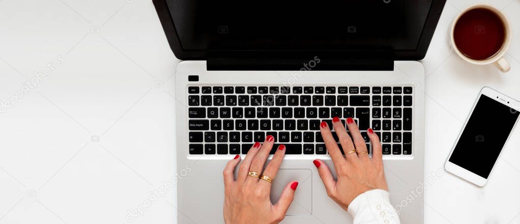 Corporate business woman working at home office desk, using laptop and smartphone. Concept of technology and communication. Flat lay