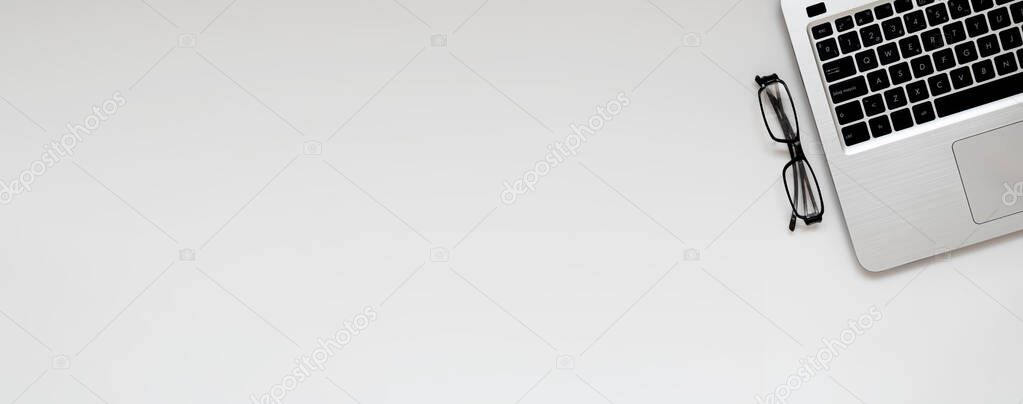 Banner of professional minimal place of work with blank copy space. Small business office with laptop and glasses. Layout, flat lay