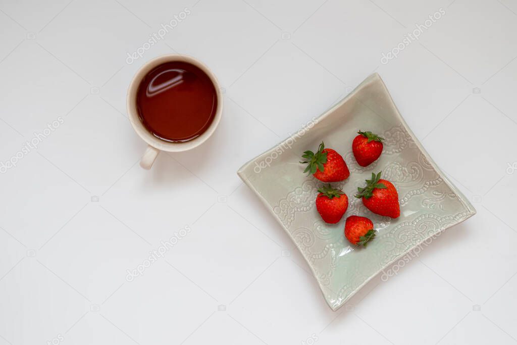Healthy, simple delicious breakfast: homemade coffee espresso with strawberries in a porcelain plate. Flat lay