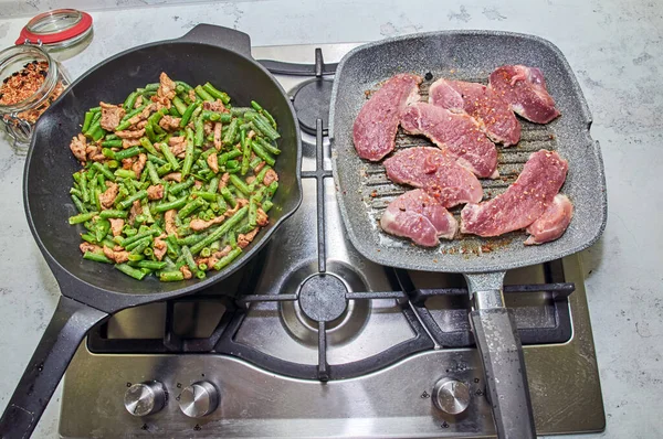 Two Frying Pans Stove Light Countertop Green Beans Bell Pepper Stock Image