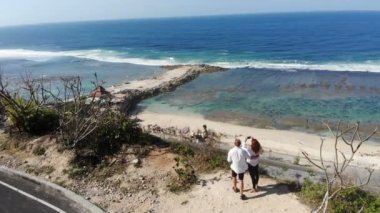 Romantic young couple stays on the edge near the ocean
