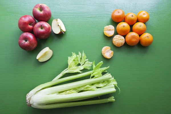 Kereviz, elma ve ahşap zemin üzerine mandalina