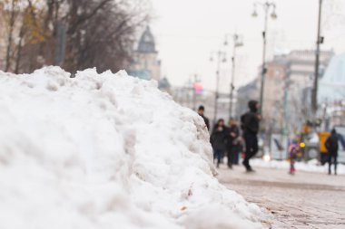Kış frost kaldırım parçası. Kazık toplanan kar ve sonbahar yaprakları. Şehir sokak