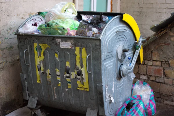 Outdoor trash bin with food waste. Not sorted garbage, yard, stench, filth