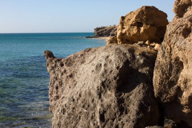 Costa Calma Beach siyah kayalar. Mavi kıyı şeridi. Playa Barca, Fuerteventura, Kanarya Adaları, İspanya. Istmo de la pared görünümü