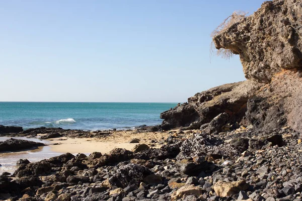 Rocas negras de la playa Costa Calma. Costa Azul. Playa Barca, Fuerteventura, Islas Canarias, España. Istmo de la vista perdonada — Foto de Stock