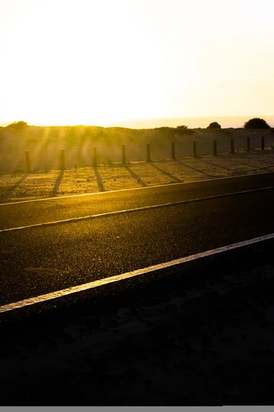 Strada asfaltata costiera. Alba su cappotto d'asfalto, macro foto della strada. Alla spiaggia. Autostrada in Spagna . — Foto Stock