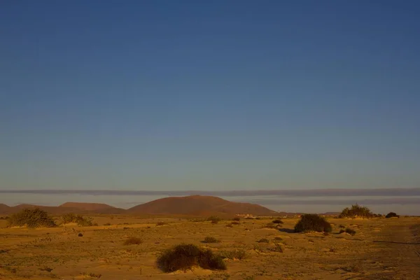 Geel zand op woestijnlandschap. Panoramisch uitzicht. Fuerteventura, Canarische eilanden — Stockfoto