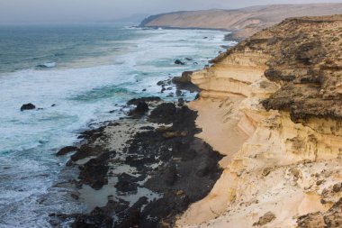 Panoramik okyanus manzaralı. Volkan, siyah kayalar. Kum makro. Deniz arka plan. Ufuk.