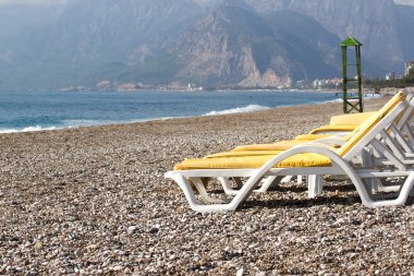 Mavi suya yakın sahilde boş plaj sandalyeleri, Kemer, Türkiye, Akdeniz.