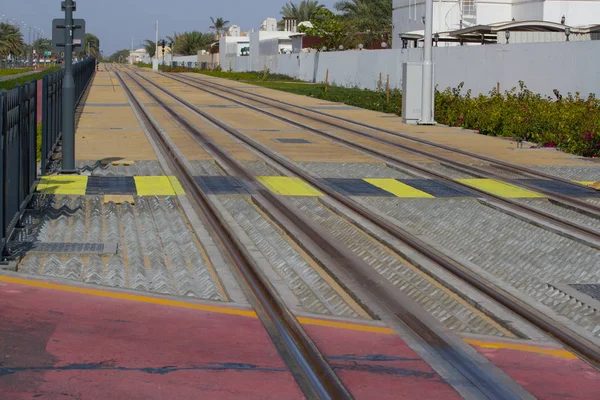 दुबई में ट्राम स्टॉप पर रेल के माध्यम से सुरक्षित मार्ग। रेलवे पैदल यात्री क्रॉसिंग। रंगीन ज़ेबरा . — स्टॉक फ़ोटो, इमेज