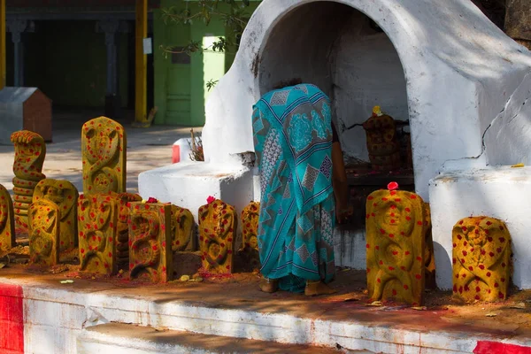 Žena připomínající mrtvé v chrámu. Skupina žlutých památek s červenými tečkami ve svatyni Šiva, Tamilnádu, Indie. — Stock fotografie