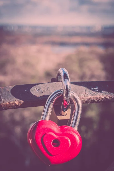 Symbol för kärlek. Vintage kort med rött hjärta bakgrund. Metall lås på bron älskare. — Stockfoto