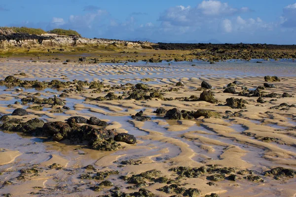 Brillante fondo de arena y cielo. Patrón de ondulación de arena y agua del océano Atlántico. Desierto diferentes impresiones —  Fotos de Stock