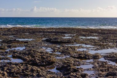 Lav alanları. Siyah mineraller. Kõyõ alanlarõ arazi ve su Fuerteventura ve Atlas Okyanusu arasında. İspanya, Europe.