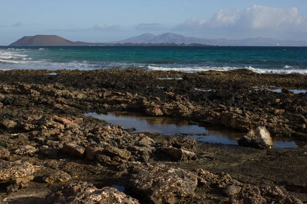 Campos de lava. Minerales negros. Zona costera entre tierra y agua en Fuerteventura y Océano Atlántico. España, Europa . — Foto de Stock