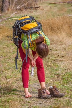 Güzel kız ormanda ayakkabı olmadan yaslanmış. Beyaz kadının uzun trekking sonra bir dinlenme vardır