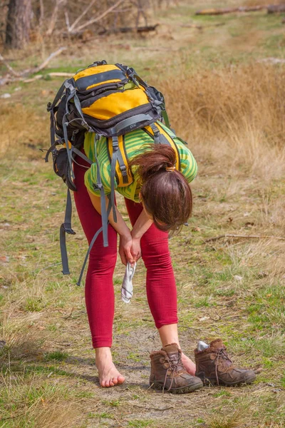 Güzel kız ormanda ayakkabı olmadan yaslanmış. Beyaz kadının uzun trekking sonra bir dinlenme vardır