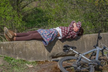 Ormanda bisiklet gezisi sonra dinlenmek zaman zevk kask giyen güzel genç kadın. Bisikletle yakın yalan