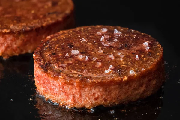 Hambúrgueres vegetarianos à base de plantas com sal de rocha sendo cozido — Fotografia de Stock