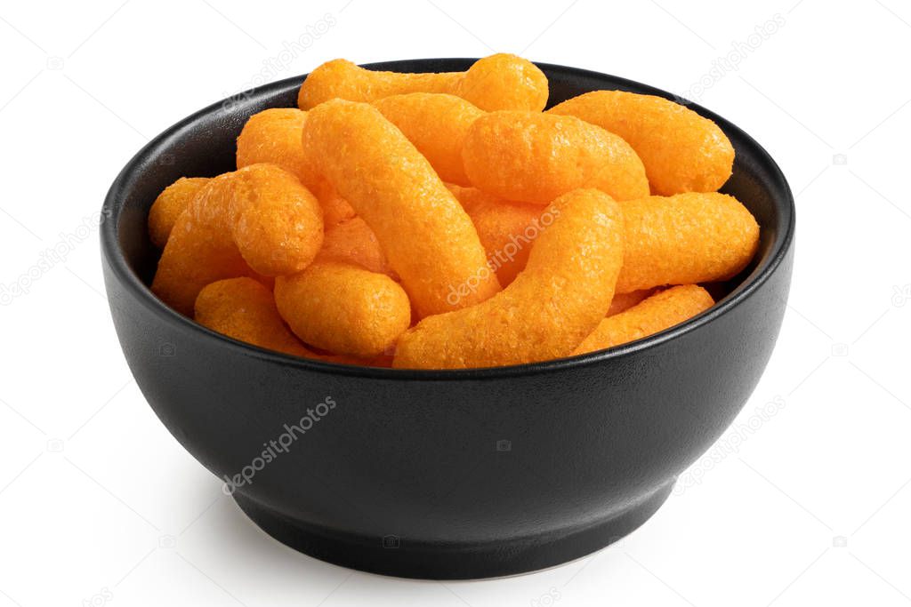 Extruded cheese puffs in a black ceramic bowl isolated on white.