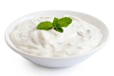 Beyaz seramik kasedeki Tzatziki beyaza izole edilmiş. Nane yaprağı baharı