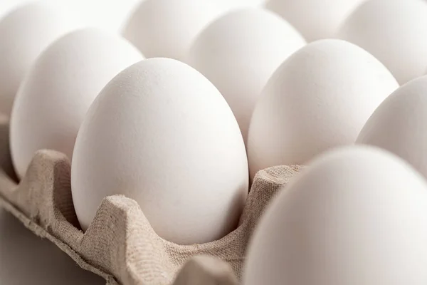 Detail of white chicken eggs in paper a tray. — Stock Photo, Image