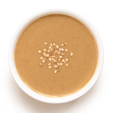 Tahini beyaz seramik bir kaseye serpiştirilmiş susam tohumları serpiştirilmiş. Üst görünüm.