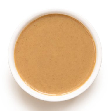 Tahini beyaz bir seramik kasede izole edilmiş. Üst görünüm.