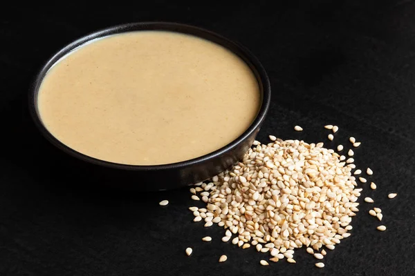 Tahini Black Ceramic Bowl Next Pile Sesame Seeds Isolated Black — Stock Photo, Image