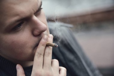 Adam içiyor bir sigara dışında portre, yakın çekim