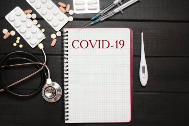 Coronavirus. Covid-19, Tıbbi Aletler, Şırınga ve Renkli Uyuşturucu ve Kapsüller İlaç Konsepti, Kahverengi Ahşap Arkaplan, Ön Görünüm, Kapalı, İzole Edilmiş