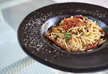 Midyeli kızarmış spagetti, kurutulmuş acı biber ve kızarmış pastırma.