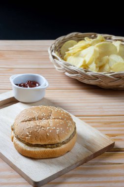 Ketçaplı, az yağlı hamburger ve patates cipsi. Yemeye hazır..