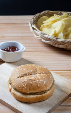 Ketçaplı, az yağlı hamburger ve patates cipsi. Yemeye hazır..