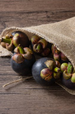 Olgun mangosteen, Tahta arka planda meyve çuvalının kraliçesi.