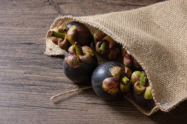 Olgun mangosteen, Tahta arka planda meyve çuvalının kraliçesi.