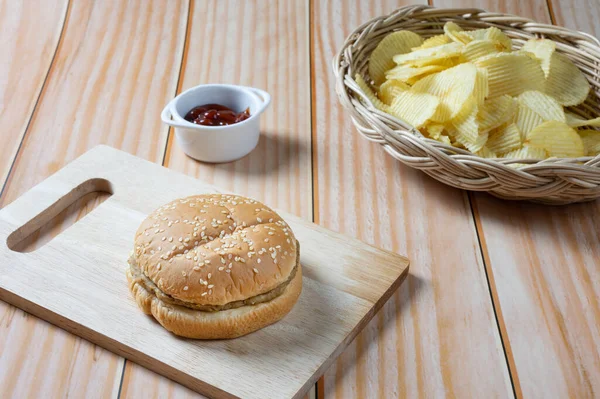 Ketçaplı, az yağlı hamburger ve patates cipsi. Yemeye hazır..