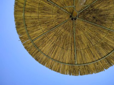 Şemsiye. Açık mavi gökyüzüne karşı. Güneş koruması. Güneşten gelen şemsiye. Yunan yaz atmosferi