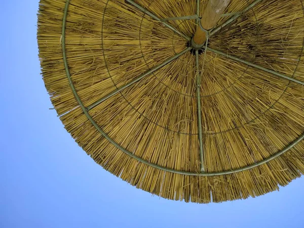 Şemsiye. Açık mavi gökyüzüne karşı. Güneş koruması. Güneşten gelen şemsiye. Yunan yaz atmosferi