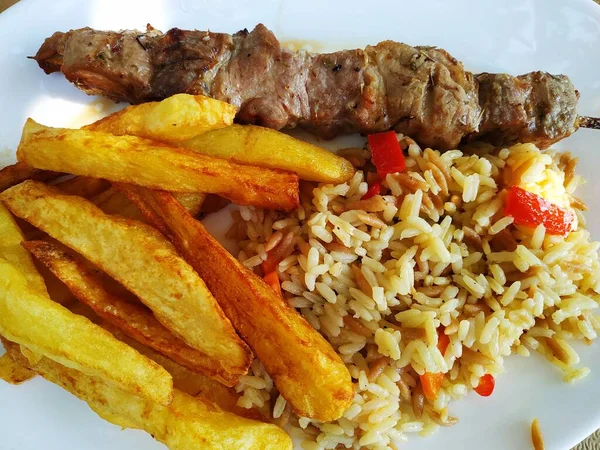 Lezzetli kebap ve meze ile tabak. Hellas 'ın geleneksel mutfağı. Rodos adasının kıyısında atıştırmalık bir şeyler. Et yemeği. Tavuk ve domuz eti lezzetleri ve garnitür.